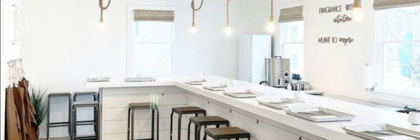 Bright and modern workspace with white desks, golden pendant lights, and minimalist decor.