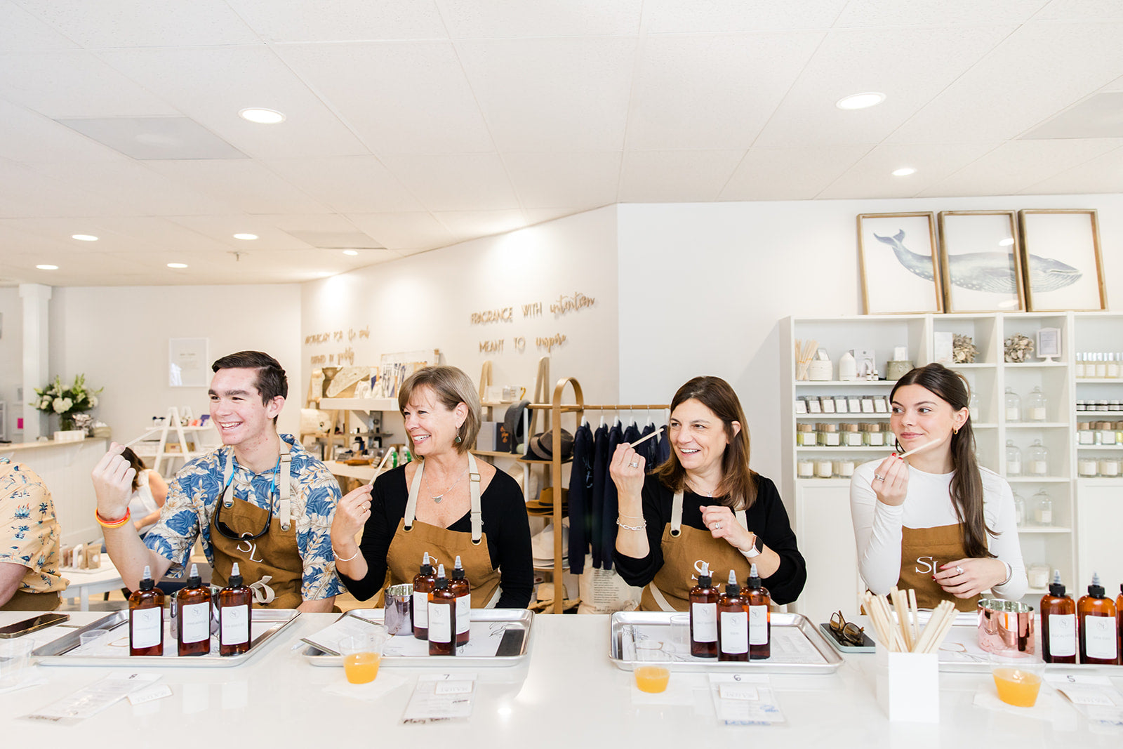 A group of happy people engaging in a candle making workshop at a bright and modern studio.